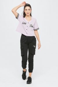 Camisa beisbolera lila y pantalón cargo negro